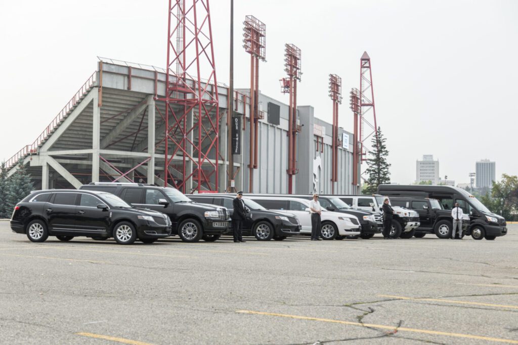 Image of Cascade Limousine Service's fleet of sedans, SUVs and stretch limos parked outside of McMahon Stadium., Calgary, Home of the Stampeders. The