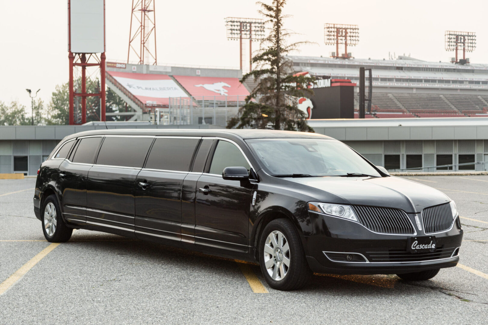 A black limousine parked in front of a stadium