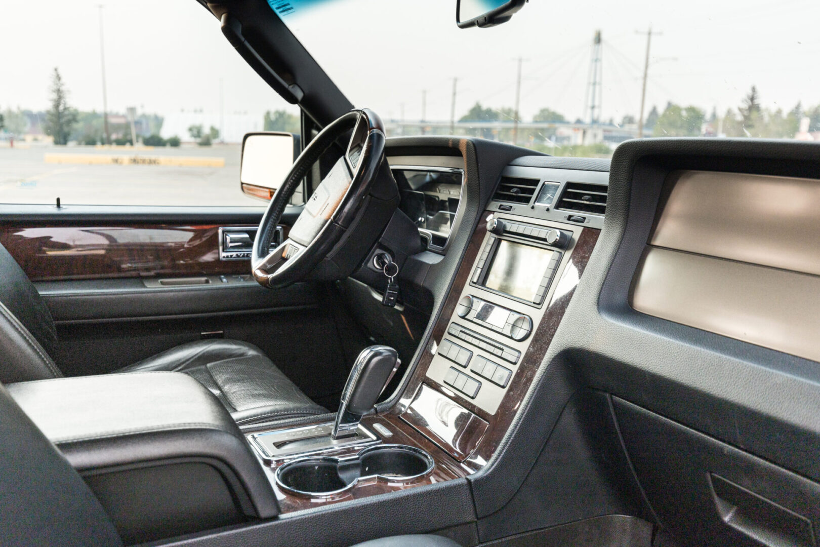 A car dashboard with the steering wheel and center console.